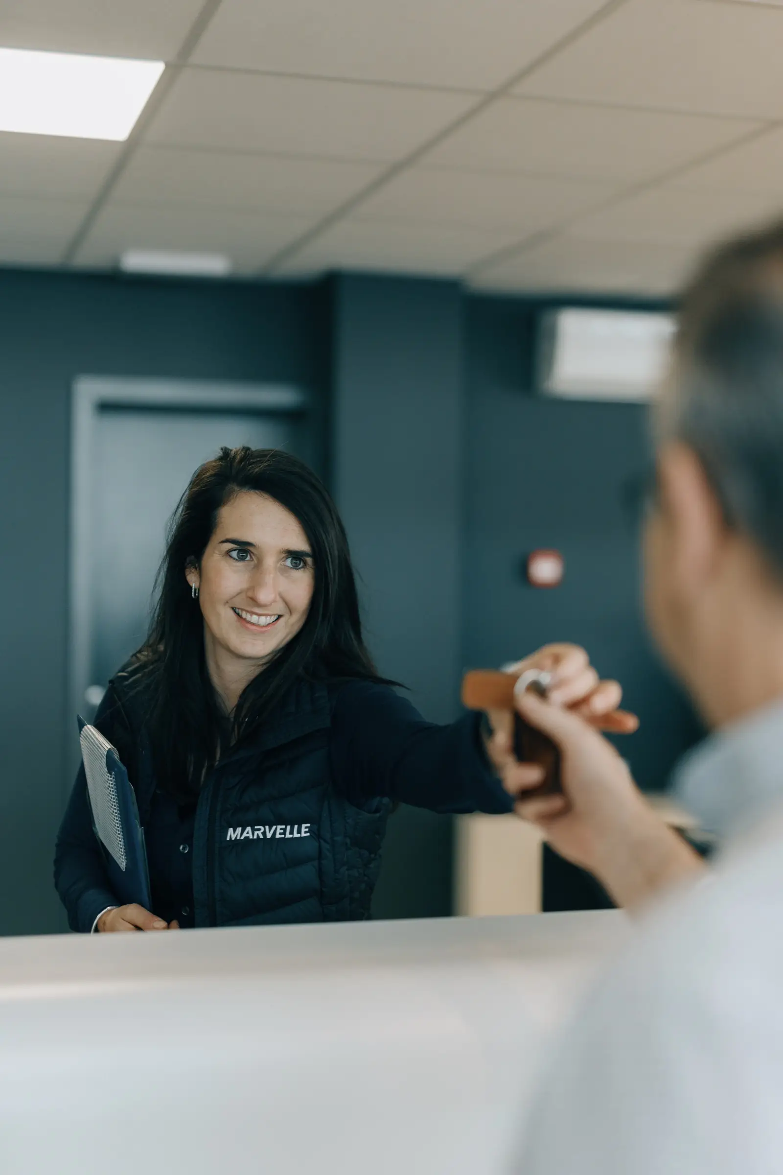 Conseillère Marvelle Automobile accueillant un client pour la reprise de son véhicule