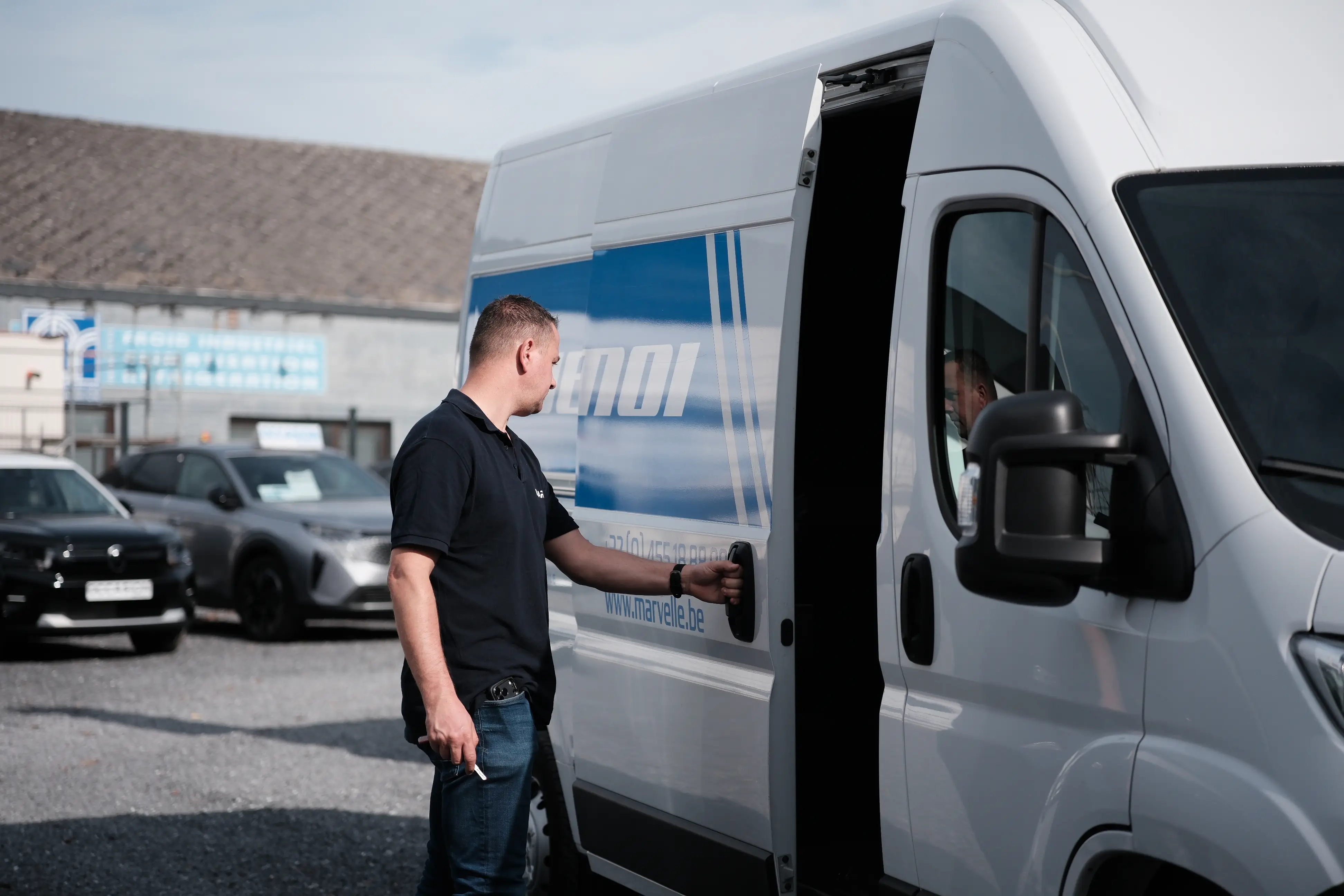 Conseiller Marvelle Automobile ouvrant la portière d'un utilitaire de location à un client